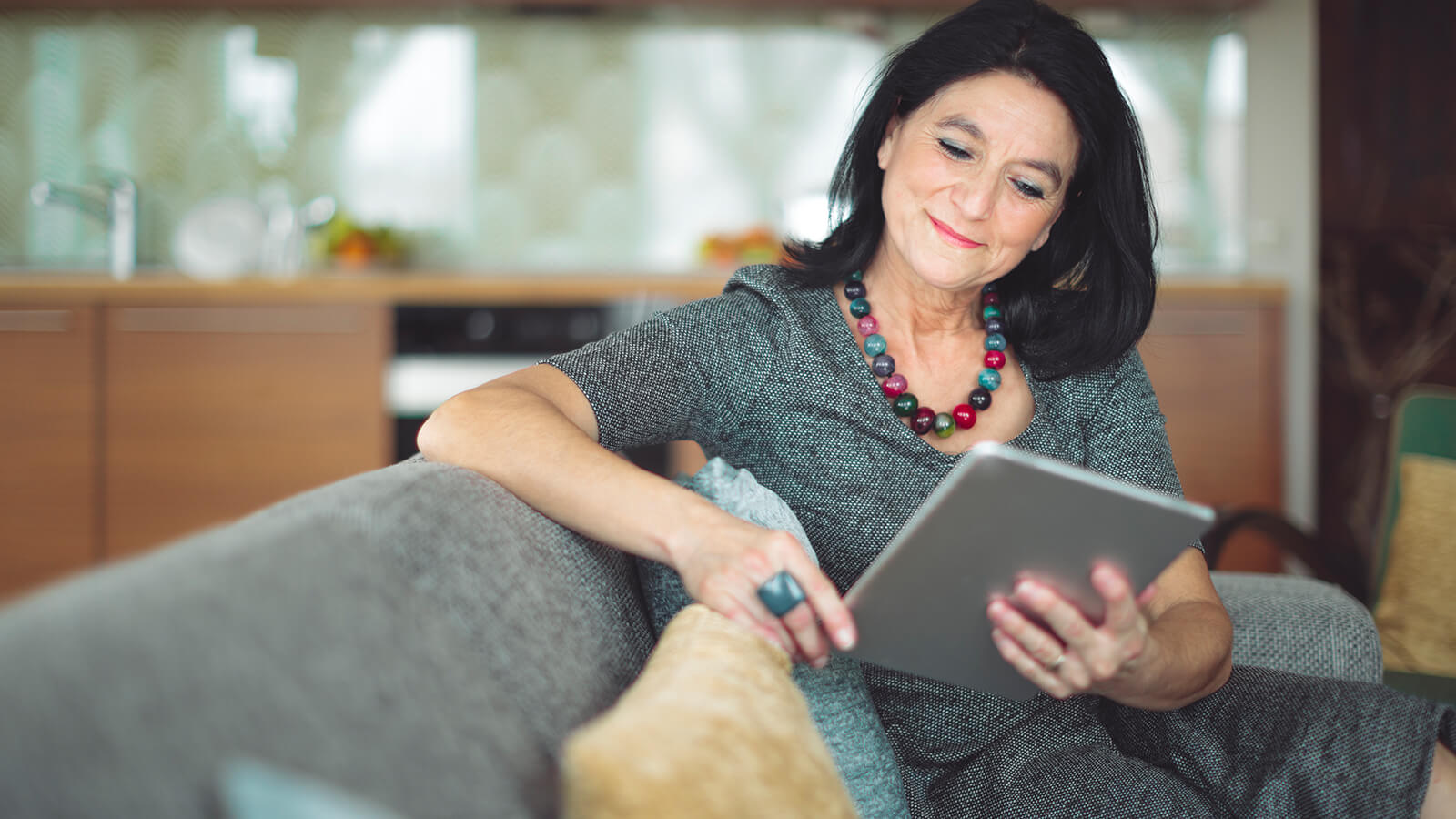 Southern Cross - A woman reads a tablet while at home A woman reads a tablet while at home