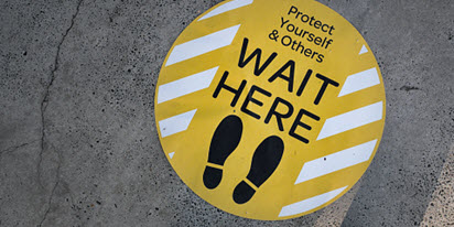 A social distancing sign on the footpath