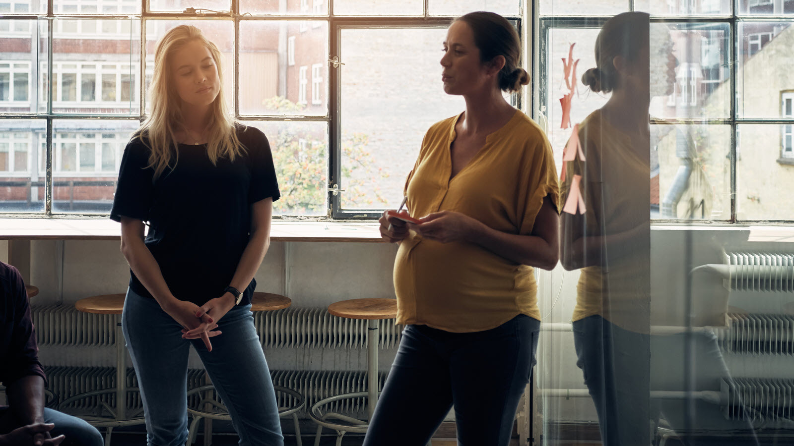 Building a workplace that supports parents and whānau A pregnant woman leading an office meeting