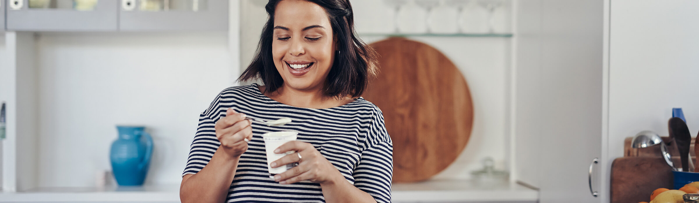 Southern Cross - A woman smiles while eating a yoghurt A woman smiles while eating a yoghurt