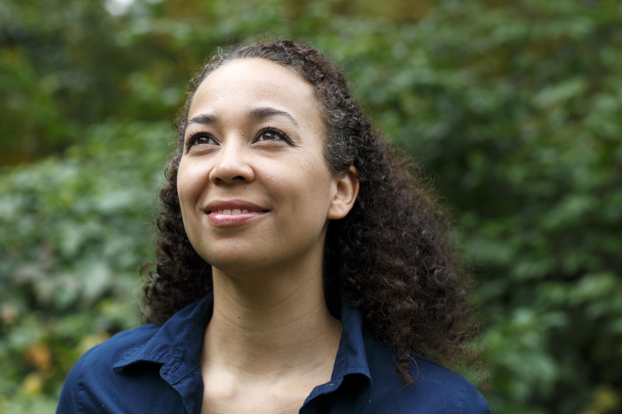 A woman smiles while she looks upwards
