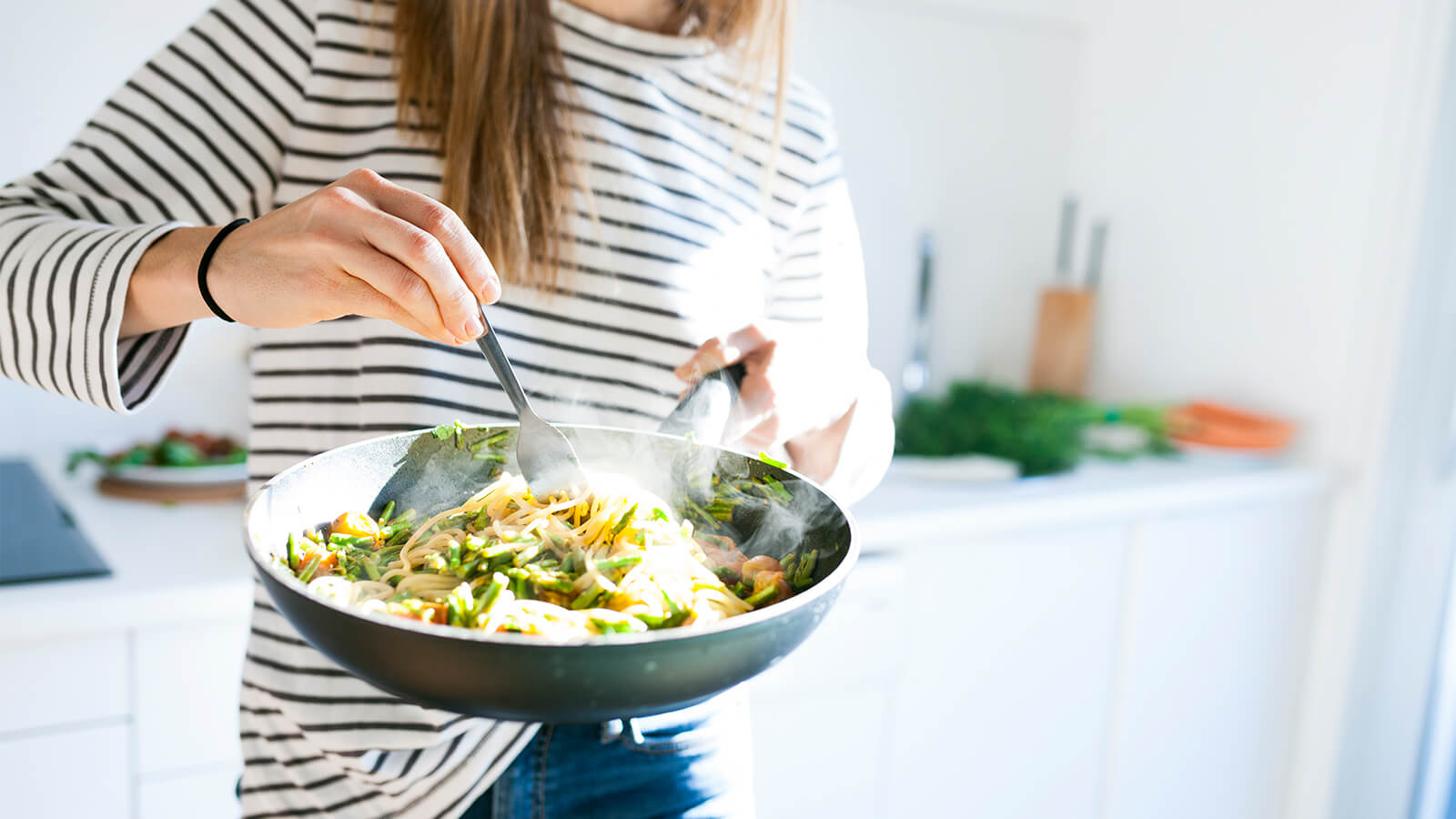 Southern Cross - A woman cooks a stir fry in a pan A woman cooks a stir fry in a pan