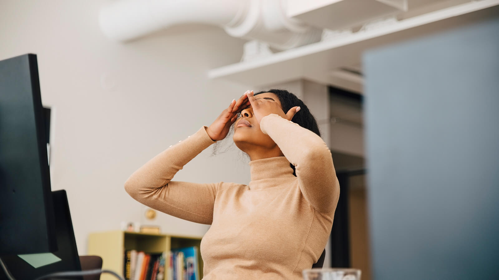 Southern Cross - A woman rubs her eyes while working at her desk A woman rubs her eyes while working at her desk