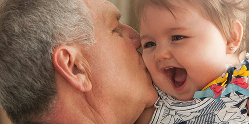 A man hugging and kissing a baby