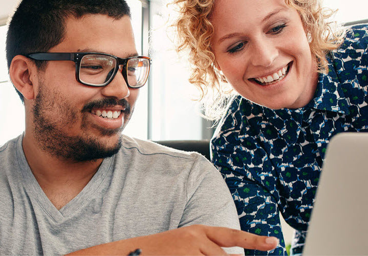 Two work colleagues looking at a laptop screen